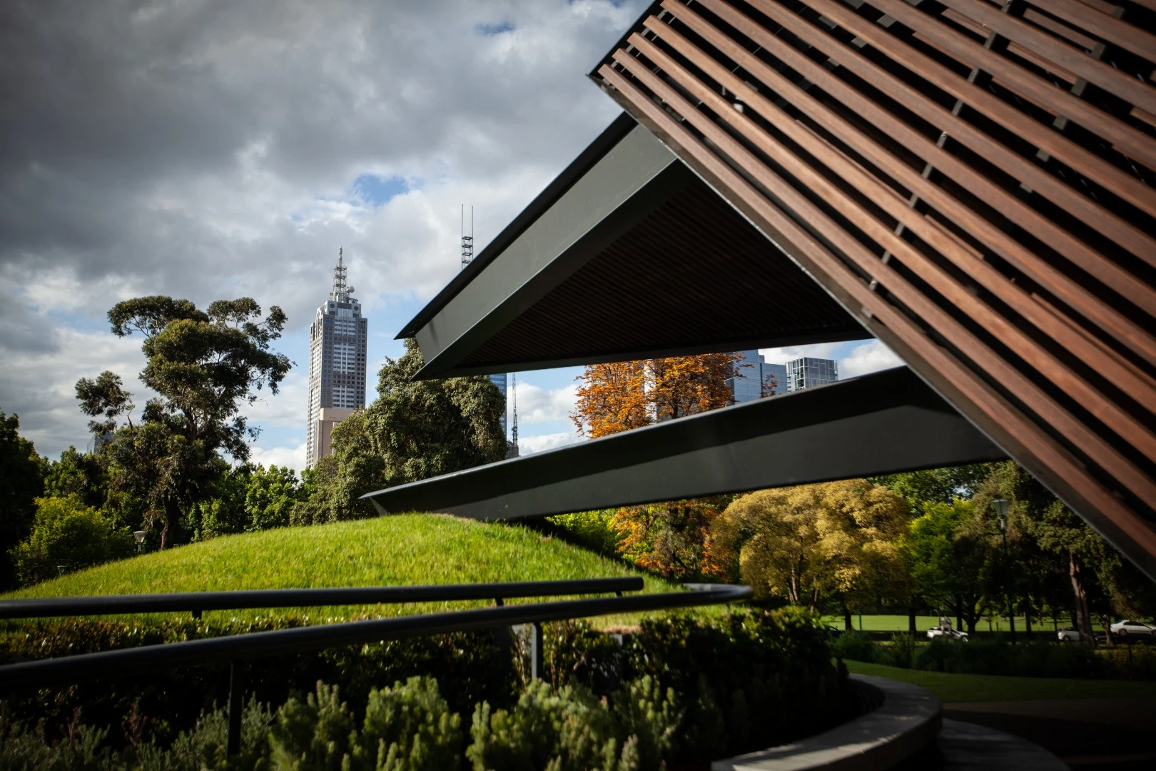 Grassy mounds surround the MPavilion and offer tiered seating, while also serving as the anchor points for the huge floating planes that make up its walls and roof