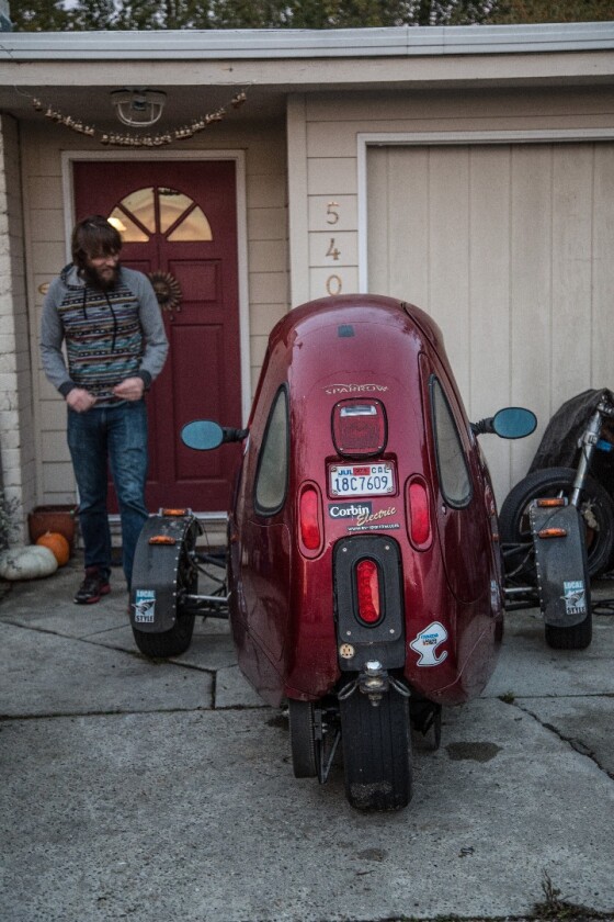 Luke Workman with his Corbin Sparrow. That's Death Bike under the tarp.