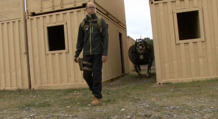 Boston Dynamics' LS3 quadruped follows a soldier through a tight corridor during a training exercise