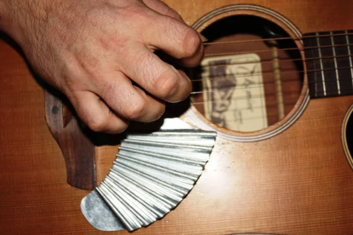 When attached below the picking area of an acoustic guitar, the Pik'N Board offers players the means to provide their own strum-stroke back beat