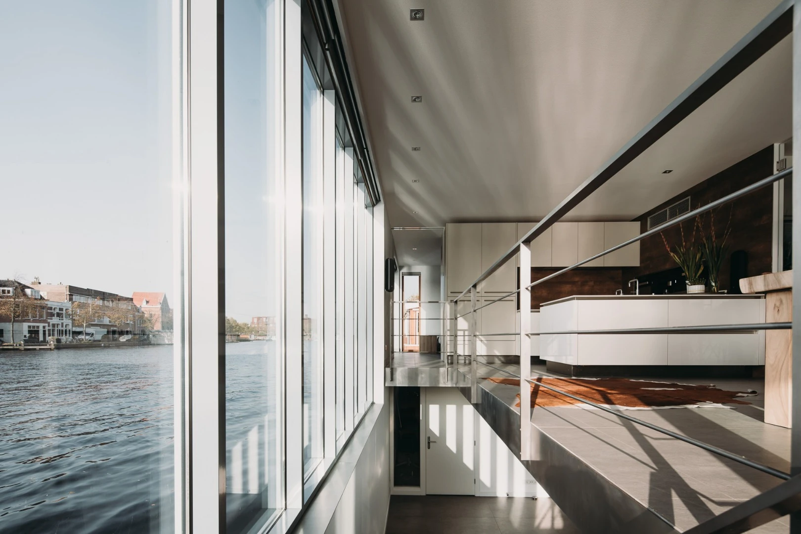 This glass wall allows natural light to filter down to the home’s lower level