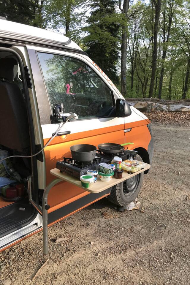 Cucina fuori sopra il tavolo e monta lo spruzzatore sopra per creare una cucina all'aperto funzionale