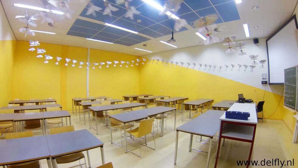 A multi-exposure shot of the DelFly Explorer flying through a lecture room