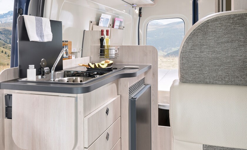 Central kitchen with flush-top sink and dual-burner stove and fridge