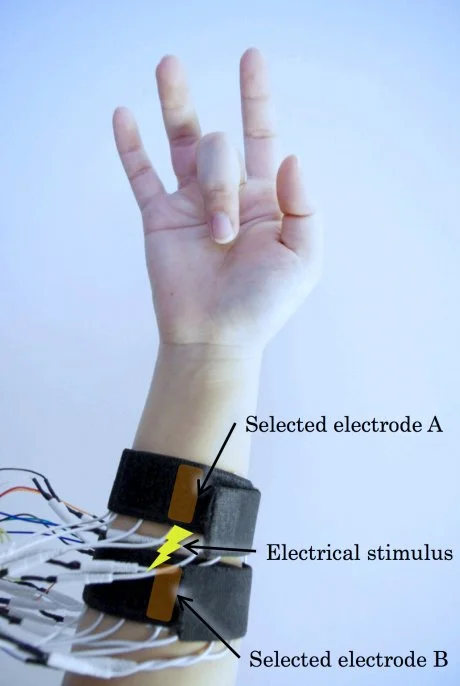 The PossessedHand forearm belts being used to control movement of the user's mid digit (Photo: Emi Tamaki and Jun Rekimoto / University of Tokyo)