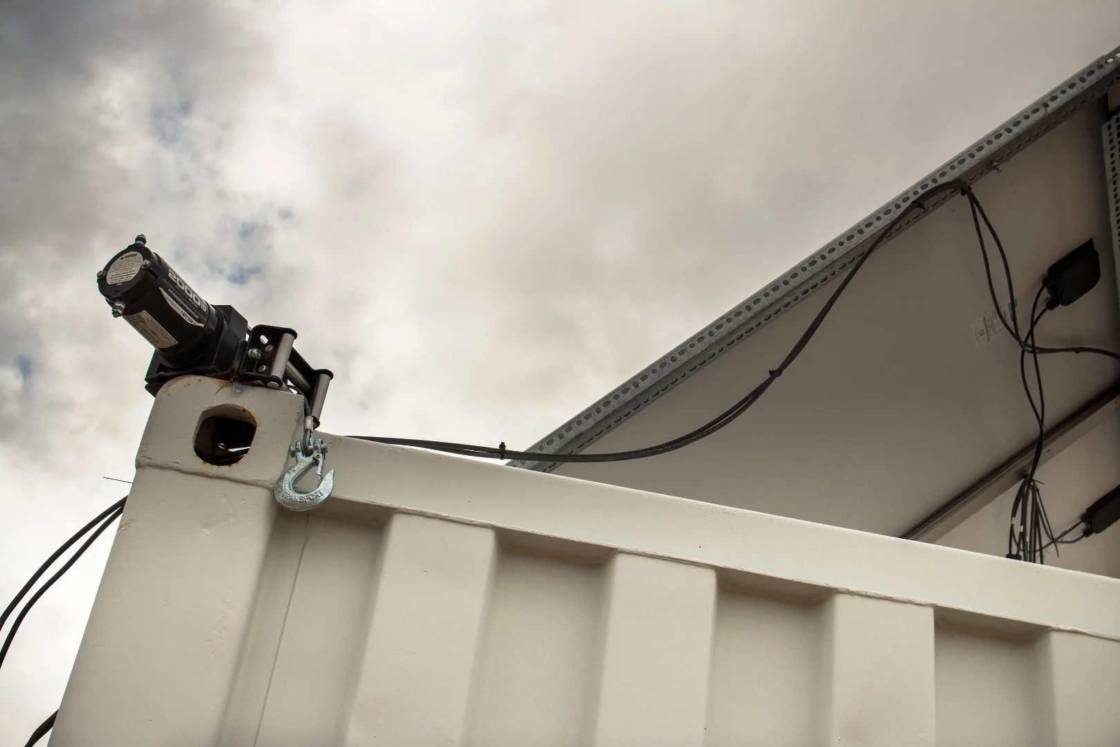 When I asked Chris about this, he laughed, telling me that it was a winch from an ATV. He had been having trouble erecting the wind turbine and with no one around to help him, he welded the winch to the shipping container to act as a second hand.