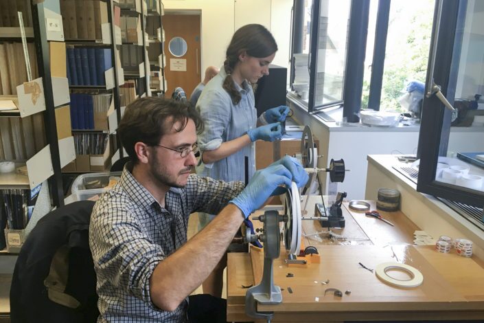 Dustin Schroeder (front) and art historian Jessica Daniel, preparing the film for digitization