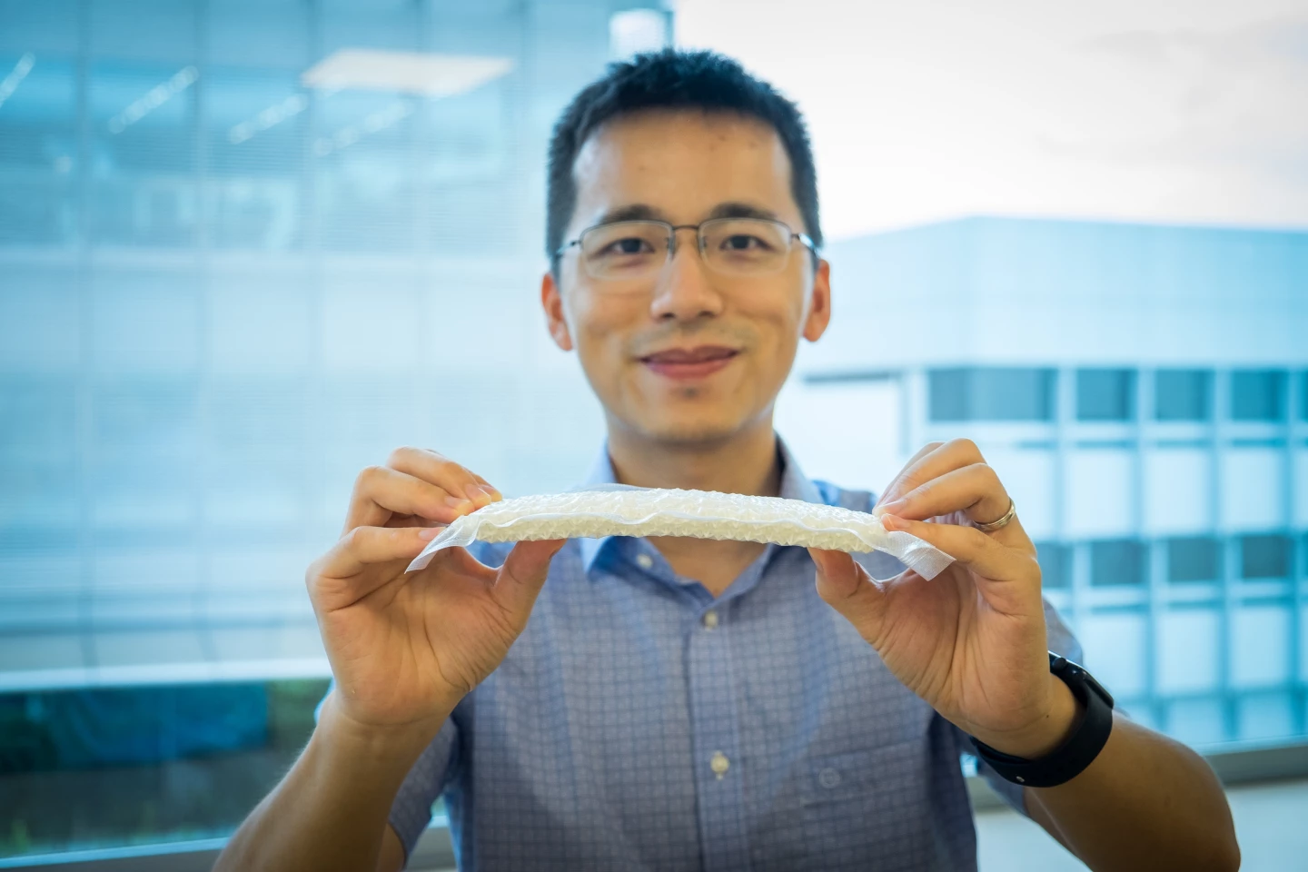 Professor Wang Yifan with a sample of the chain-mail-like material