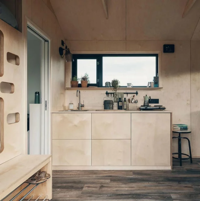 The compact timber kitchen is kept minimal and is designed to suit a short stay