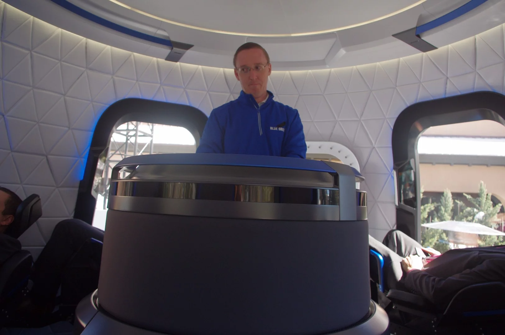 A Blue Origin representative stands in the center of the crew capsule