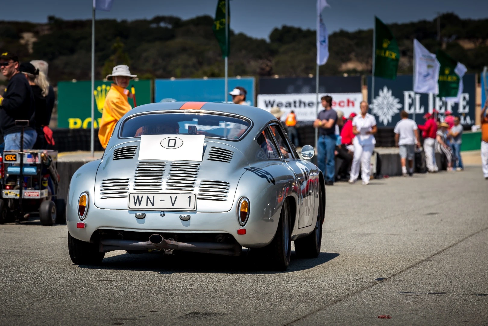 A stunning Porsche 356, sporting additional vents, makes its way down pit lane