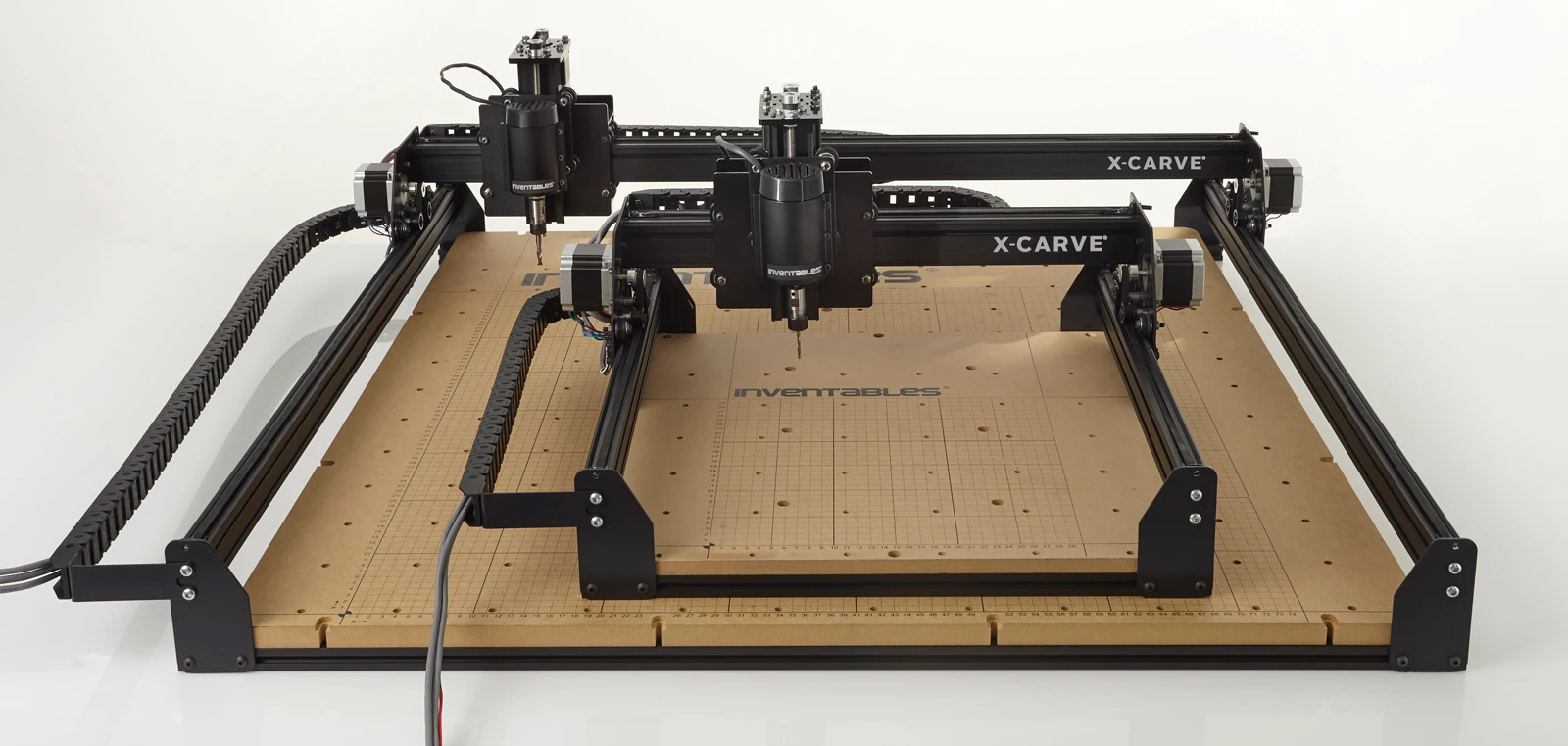 The two members of the X-Carve family, the regular sitting on top of the large model