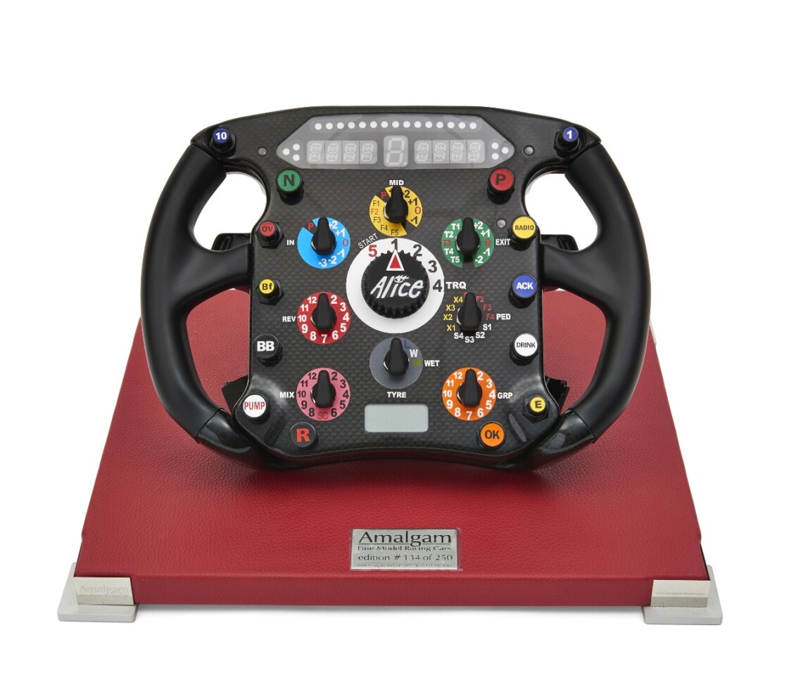 A limited edition (number 134 of 250) Ferrari F2008 Formula One steering wheel mounted on a red leather base, sold with a carrying case and a complete manual explaining the functions of the wheel. The F2008 designation indicates that this is identical to the steering wheels used in the Ferrari F2008 cars driven by Kimi Räikkönen and Felipe Massa during the 2008 season. Sold for $2,156 (€1,760)