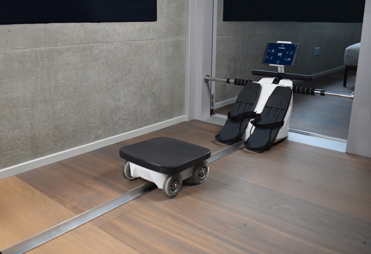 The RowBro is mounted inside the door frame and the seat rolls along the floor.
