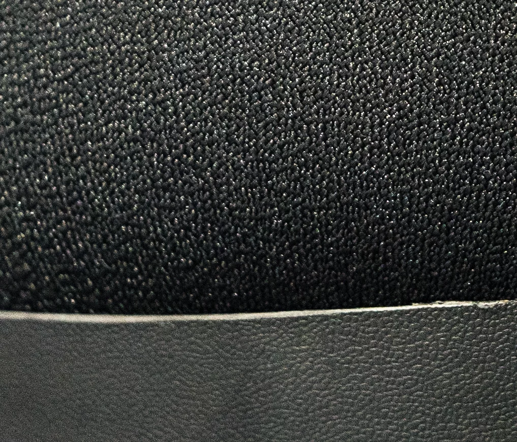 Close crop of the a9's view of a black chair in shadow under a table