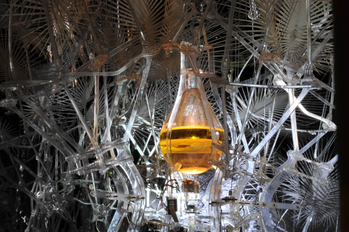 'Protocell drivers' in a flask surrounded by carbon structures, in the Hylozoic Ground installation