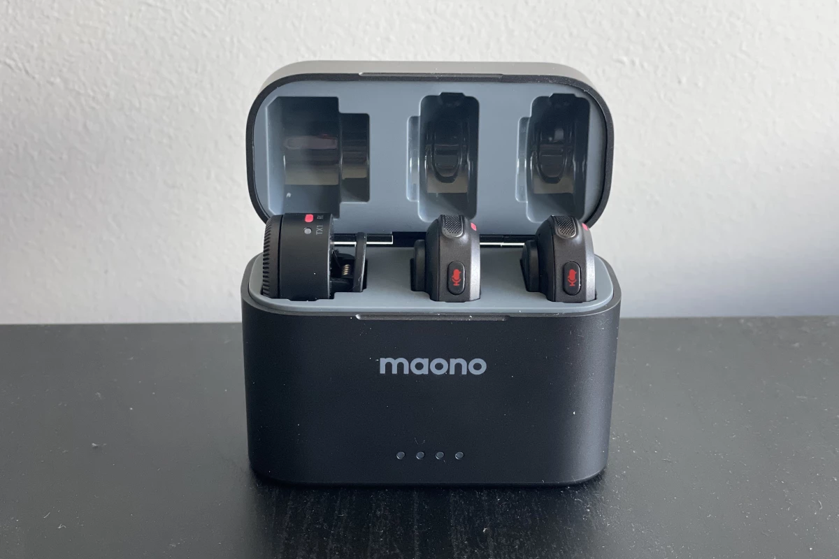 The charging case houses the two microphones and the camera receiver