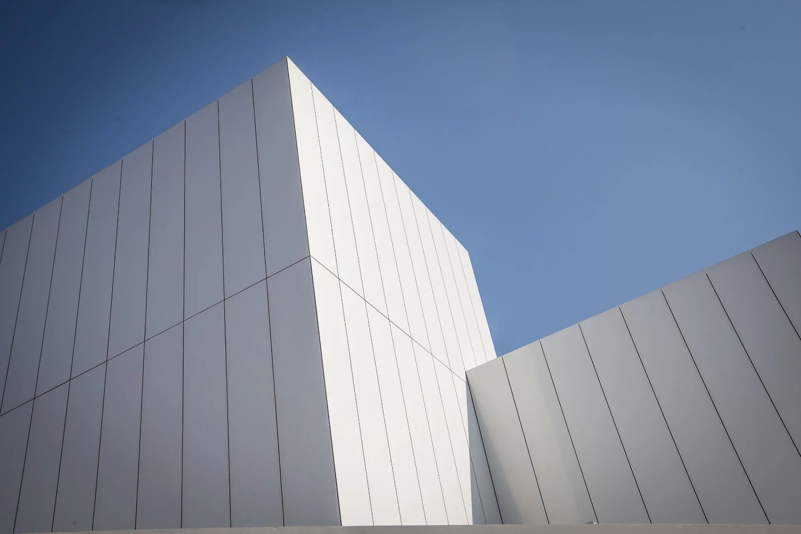 The Jameel Arts Centre's concrete and semi-reflective aluminum cladding is intended to shimmer ever so slightly in response to the surrounding water