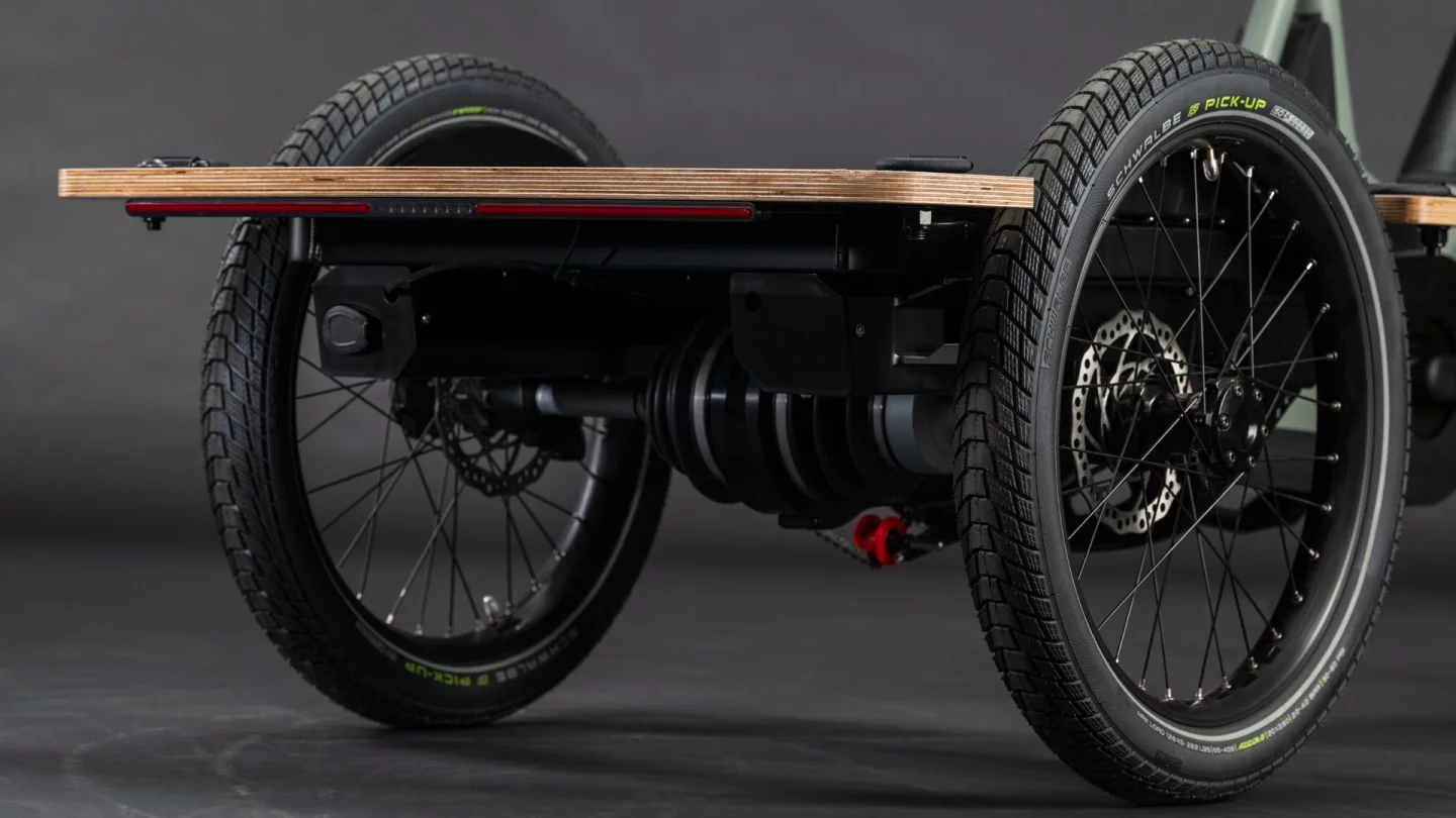 A tilting mechanism between the rear wheels keeps cargo level while allowing the rider to lean into corners