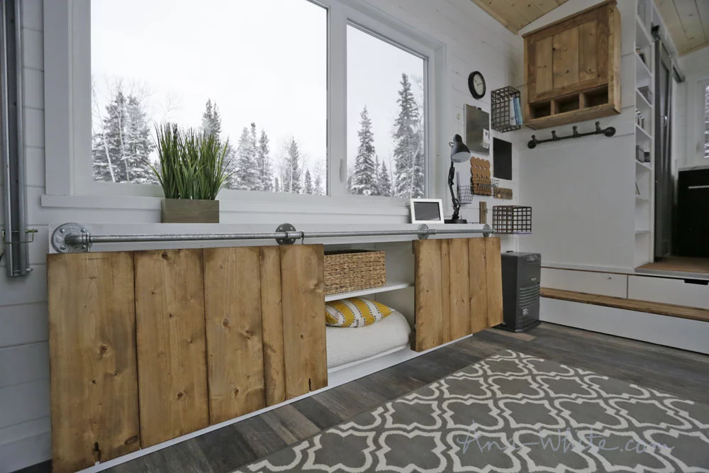 The Open Concept Rustic Modern Tiny House's storage unit with the desk sections lowered