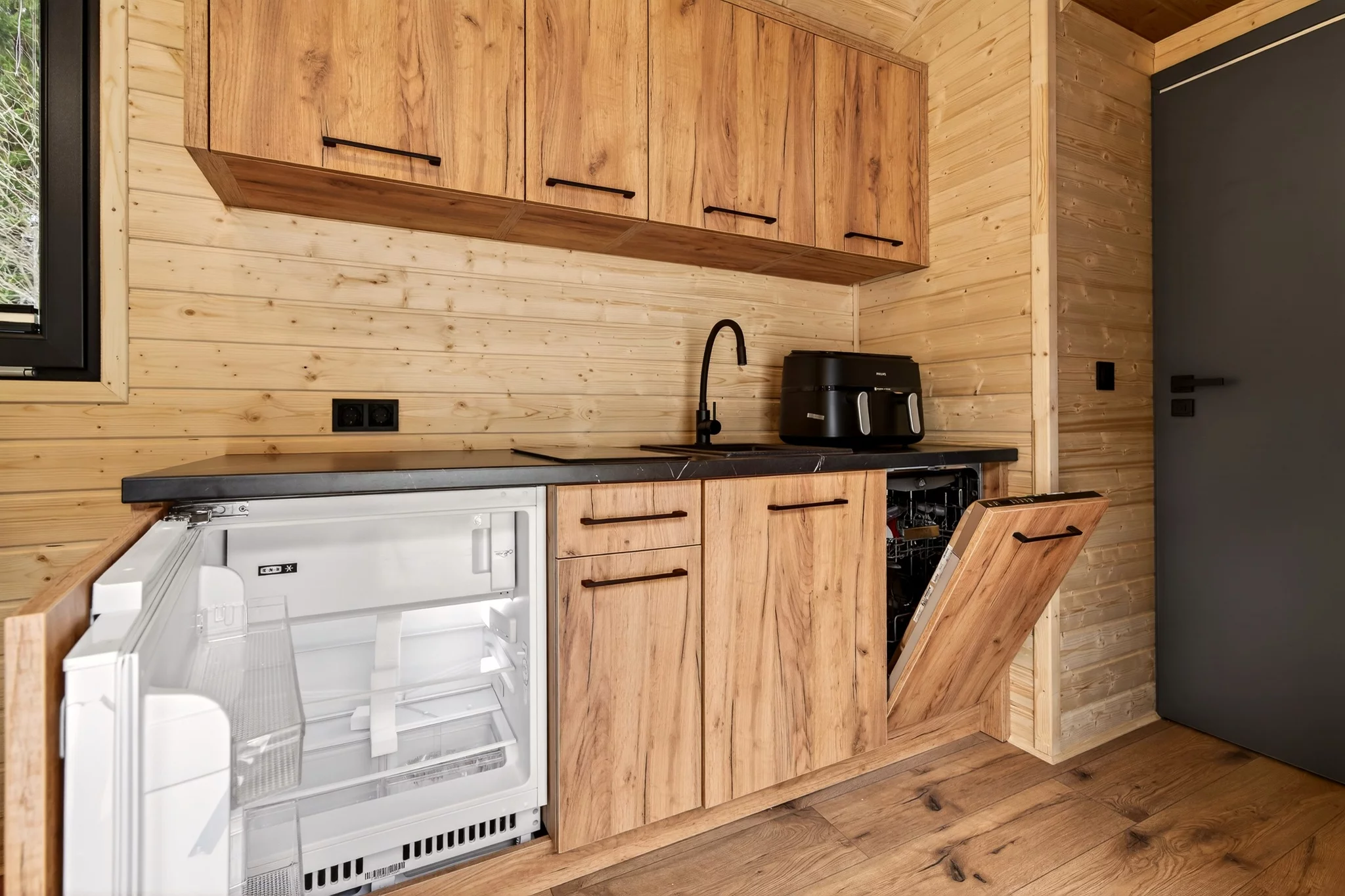 The Justine's kitchen includes an induction cooktop, an oven, a sink, a fridge/freezer, and a dishwasher
