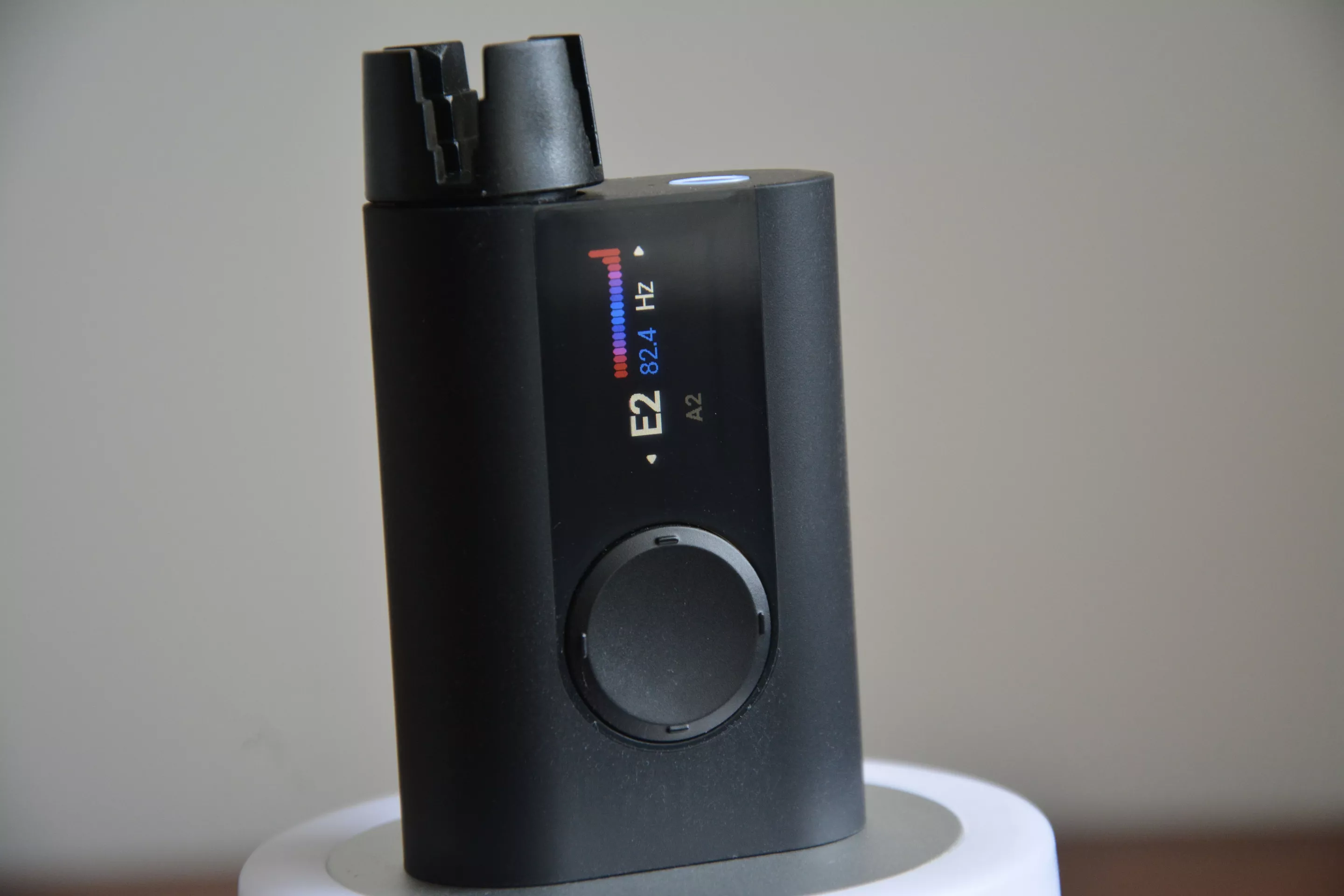 The colorful tuning screen shows the current string pitch and frequency, together with an indicator bar to show tuning progress