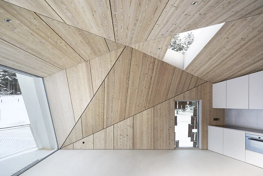 The home includes a large open living and dining area, which opens out to a triangular terrace