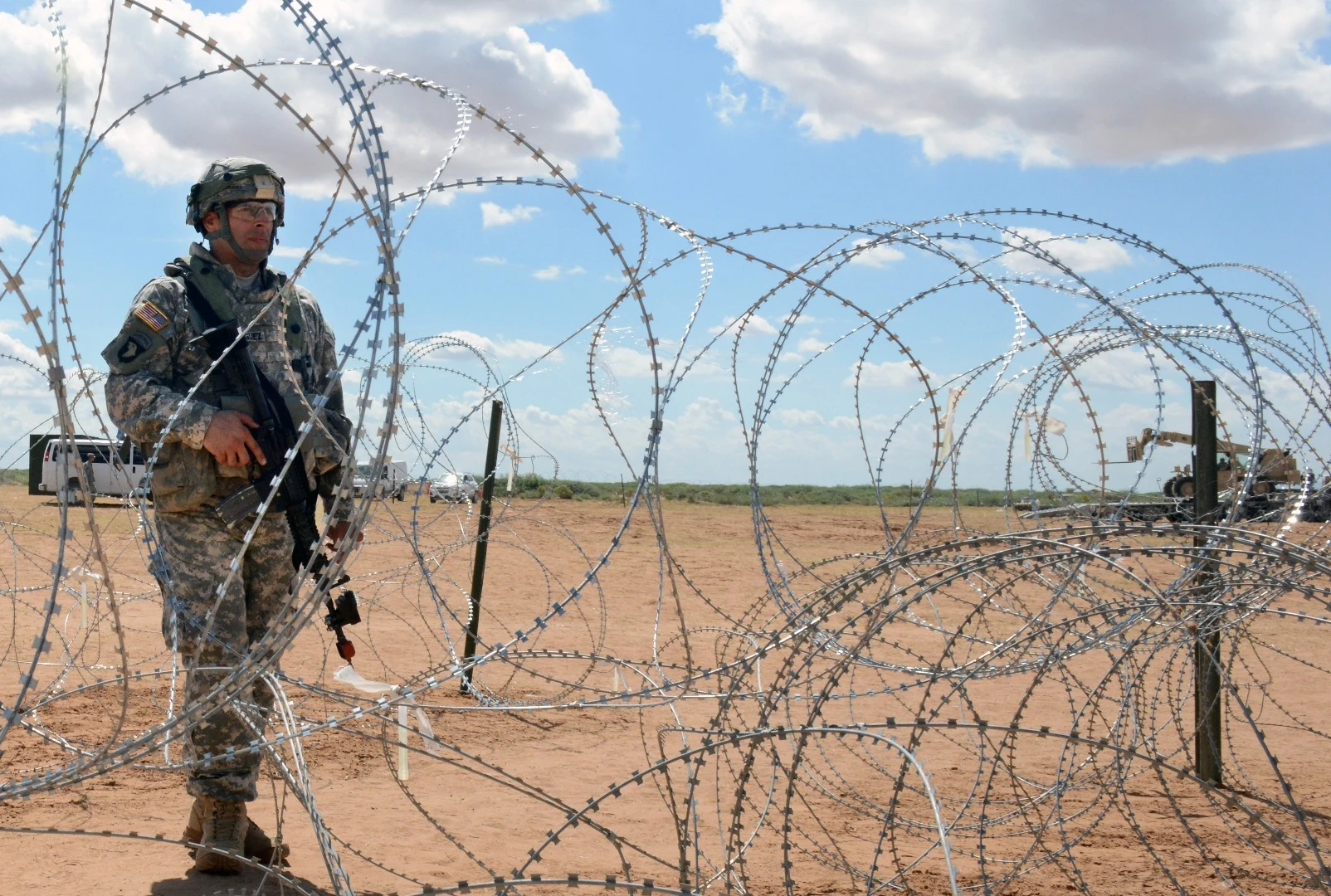 A soldier pulls security, augmenting remotely-controlled multiple weapons systems on the perimeter