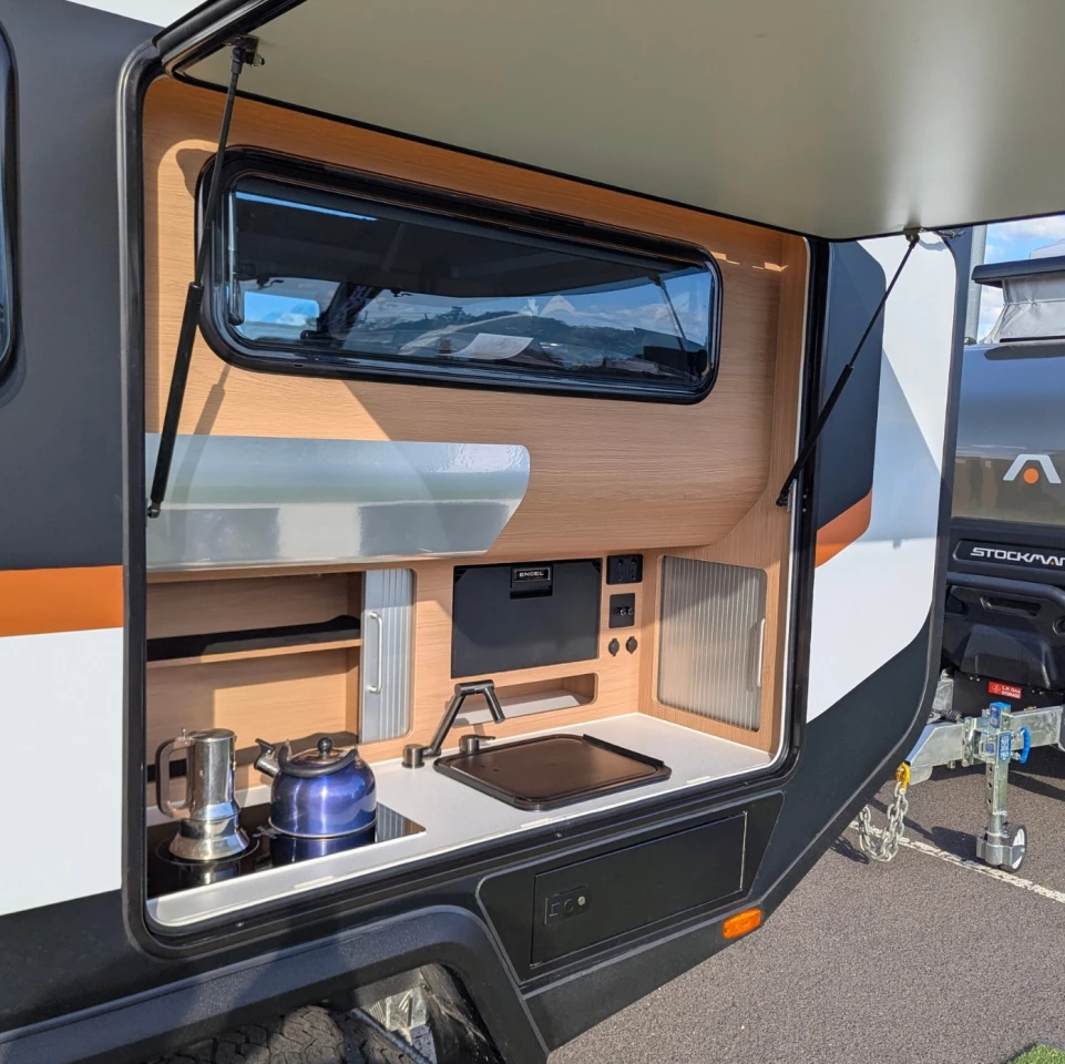 The outdoor galley includes an induction cooktop, sink and available Engel drawer fridge