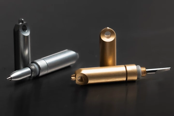 Available in titanium or brass construction, the SlashPen features a ballpoint pen, tungsten blade, Phillips screwdriver, and glass-breaking tip