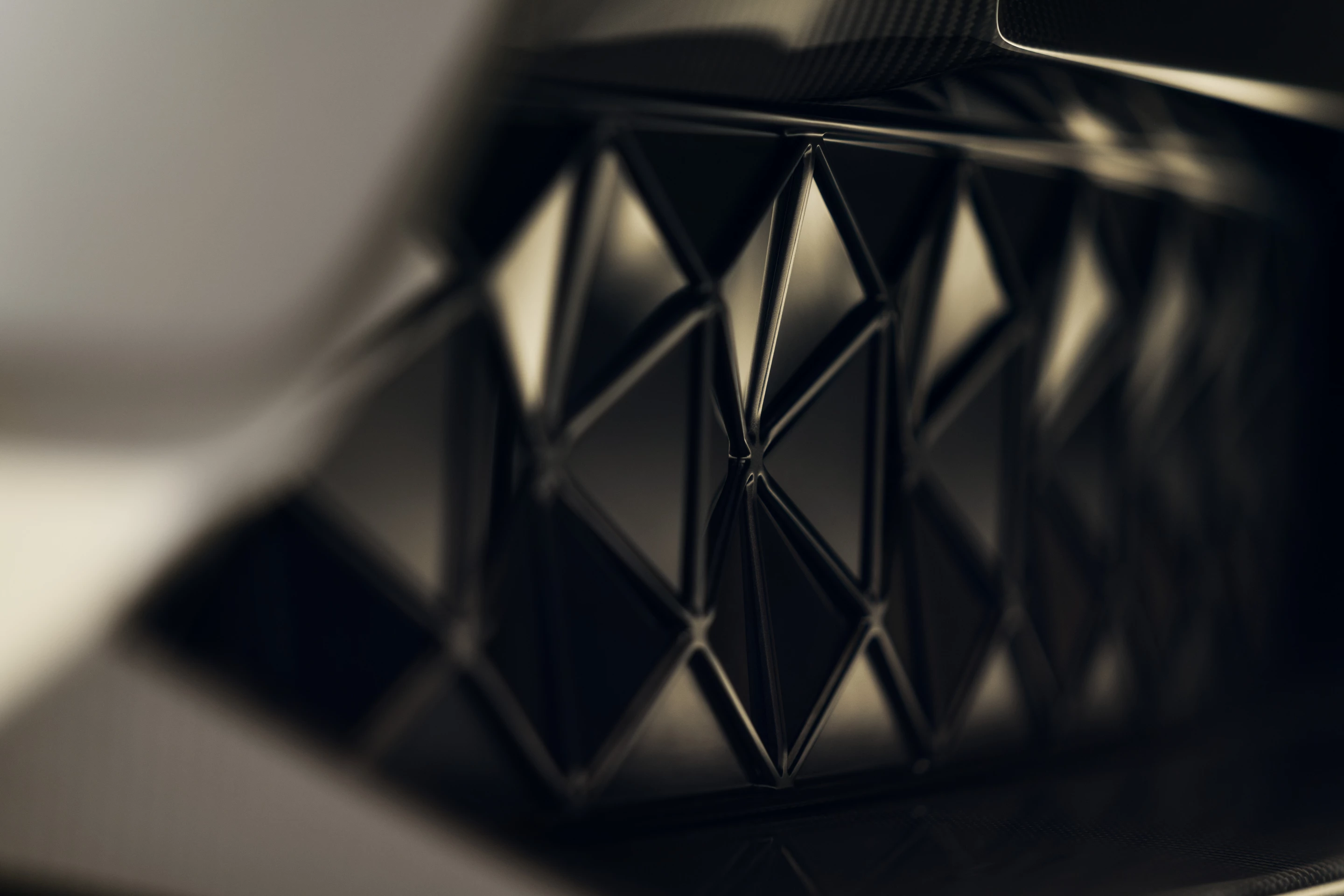 The triangles appear to be a pattern to replace the traditional grille but they serve as active aerodynamic elements to deliver cooling air