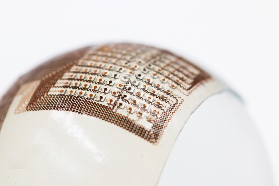 The patch consists of a thin silicone elastomer sheet with an embedded "island-bridge" electronic structure