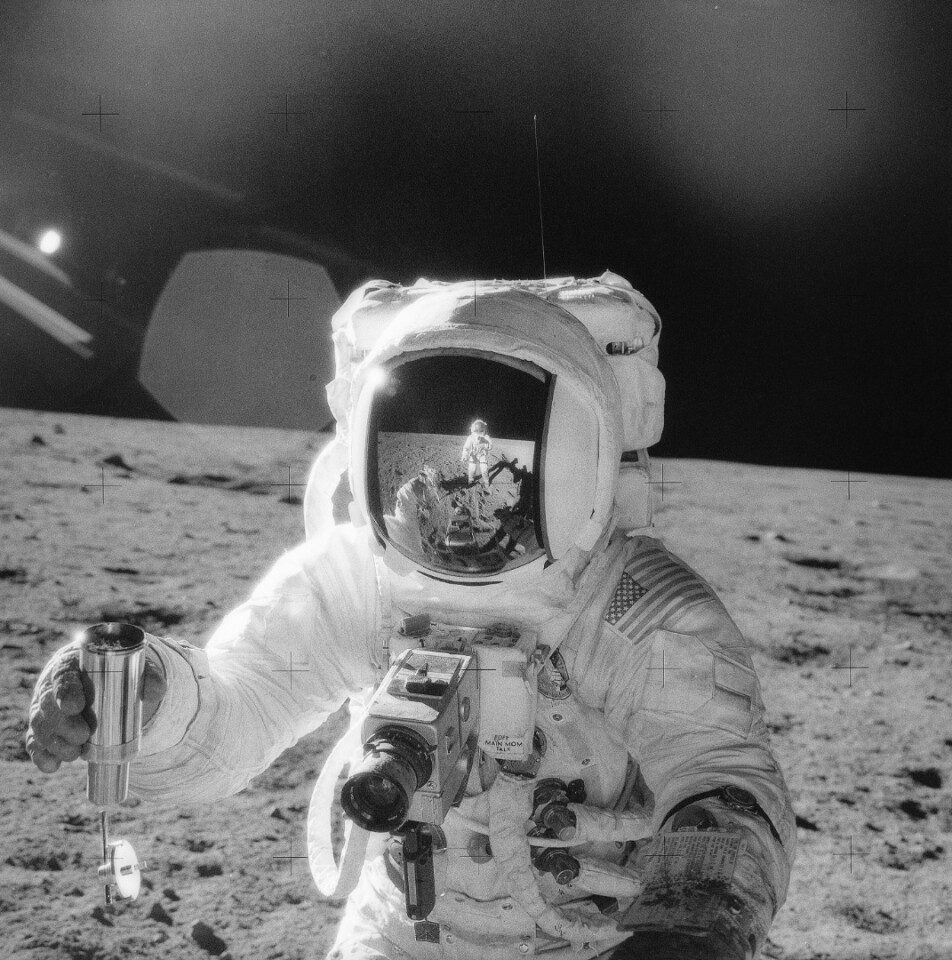 A NASA astronaut holds a container of lunar soil on the Moon’s surface in 1969