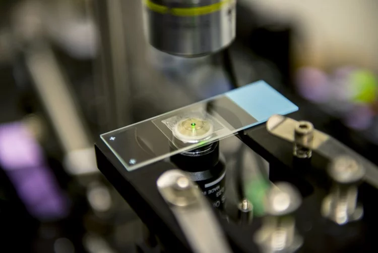 As they are cooled by the laser, the nanocrystals developed by the UW team emit a reddish-green "glow" that can be seen by the naked eye