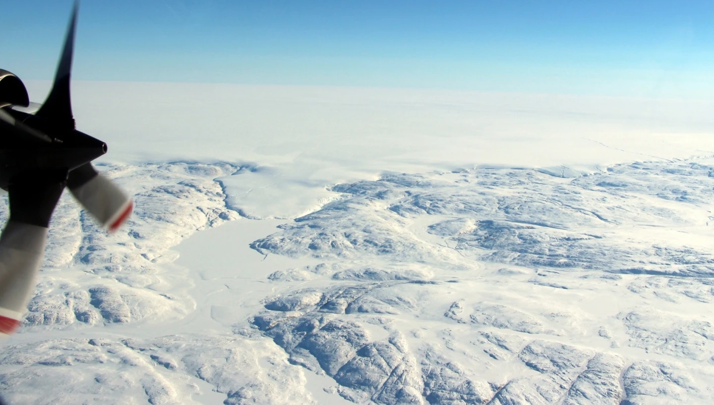 The Hiawatha impact crater is covered by the Greenland Ice Sheet, which flows just beyond the crater rim, forming a semi-circular edge