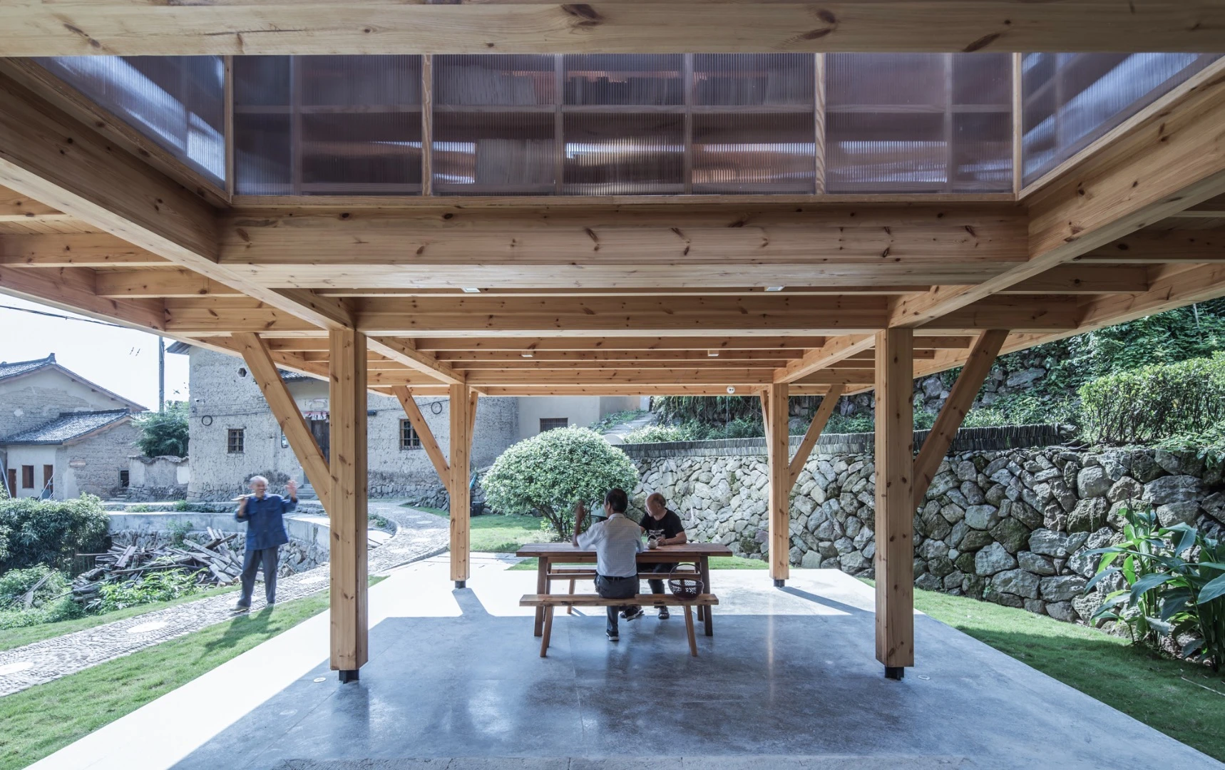 The Mountain House in Mist creates a covered semi-outdoor space beneath it that includes tables and chairs for villagers to sit and chat