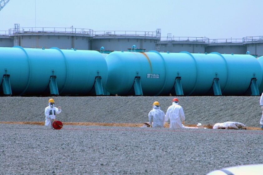 Workers at TEPCO's Fukushima Daiichi Nuclear Power Station work among underground water storage pools on 17 April 2013