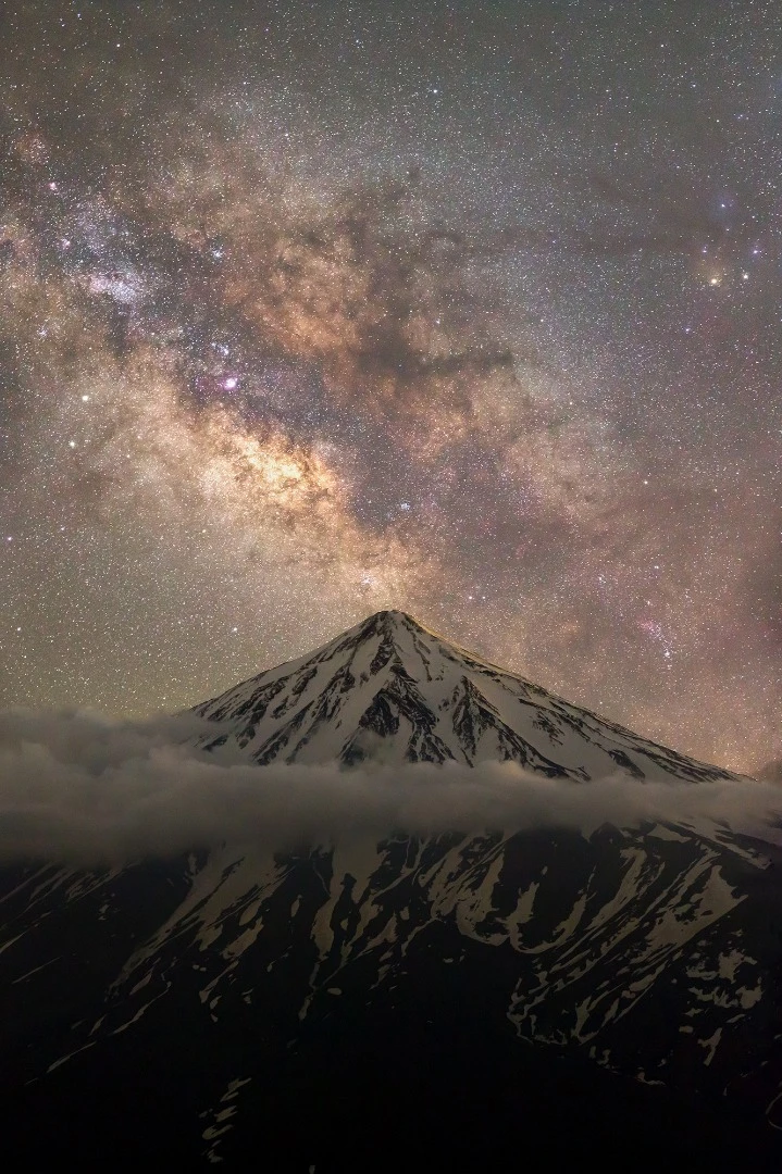 The brightest part of the Milky Way, the heart of our galaxy, towers above the peak of the grand volcanic mountain, Damavand. Mount Damavand is the highest mountain in the Middle East and the highest volcano in Asia. For the photographer this is the place that you can reach serenity.Nandal, Mazandaran Province, Iran, 8 June 2018