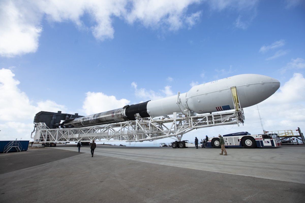 A scorched Falcon 9 is rolled out to the launchpad
