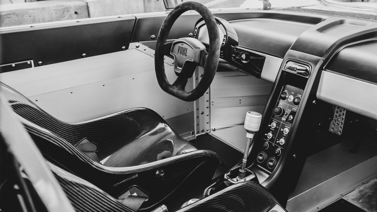 A 6-speed manual gearbox, waterproof suede, carbon fiber seats, minimalist interior and only the most essential switches and gauges make it to the cockpit