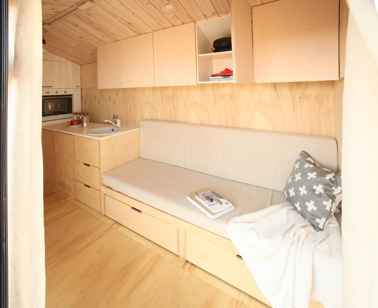The interior includes a sofa bed, an oven and fridge freezer, a boiler, a toilet, and a kitchenette