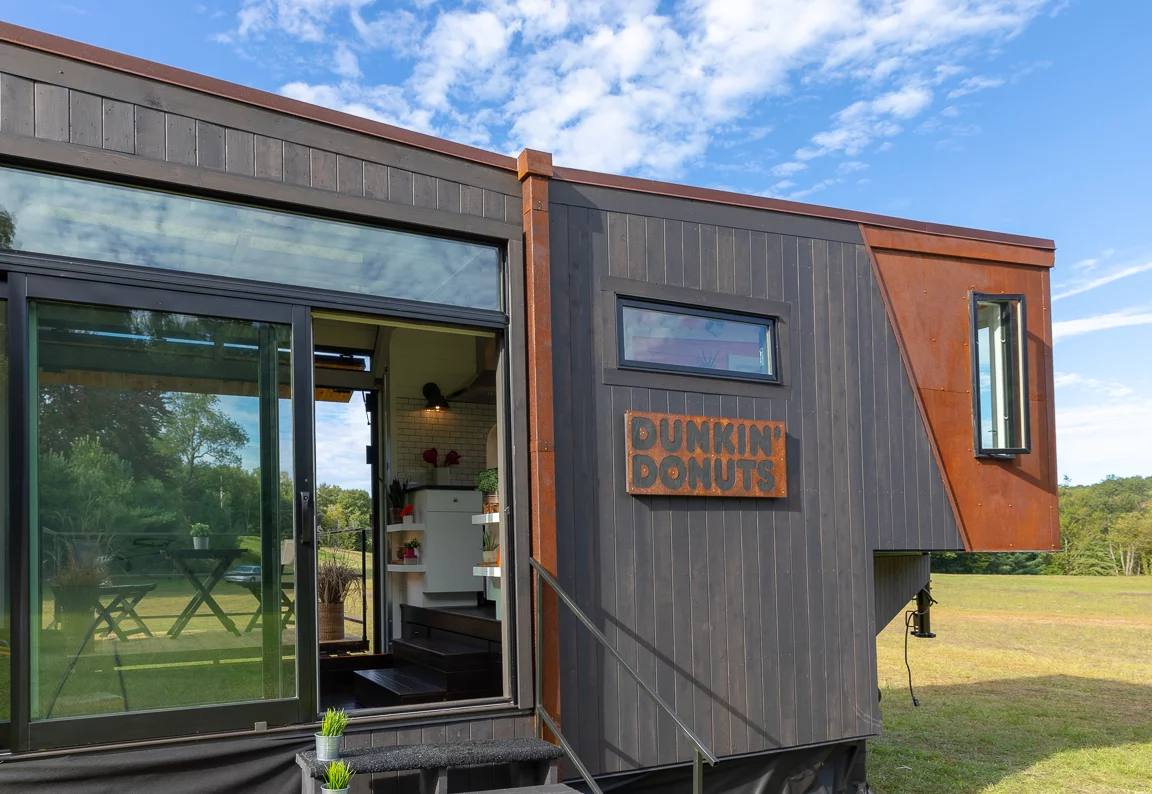 The Home That Runs on Dunkin' is clad in black stained cedar wood and weathered steel panels