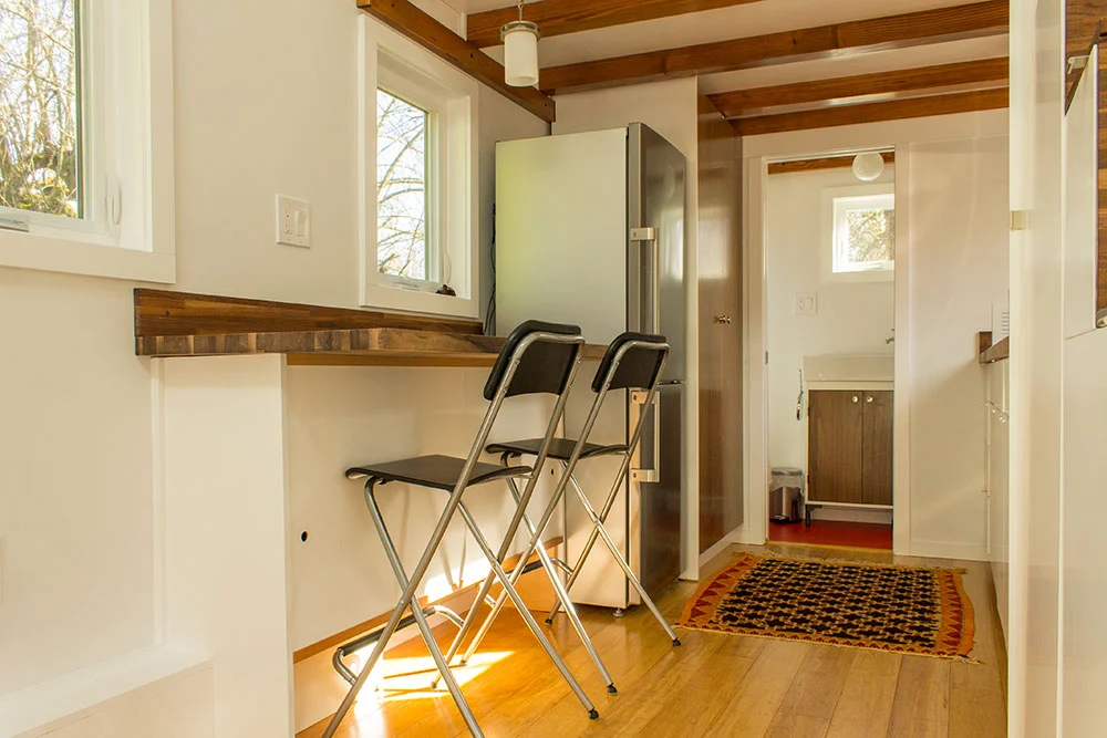 The fully equipped kitchen features a long bar-type table which can be used for dining or working