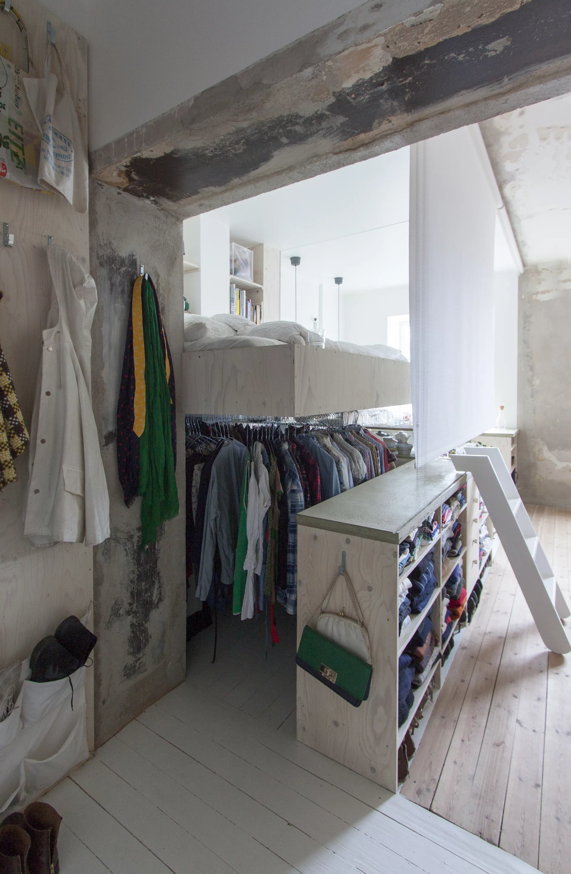 The wardrobe sits beneath the raised bed