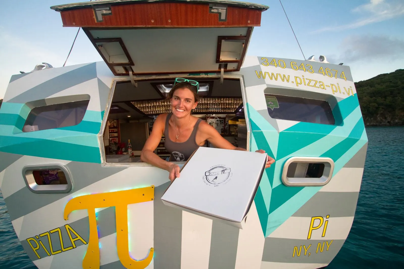 Tara Bouis proudly presents a pizza from her Pizza Pi floating business