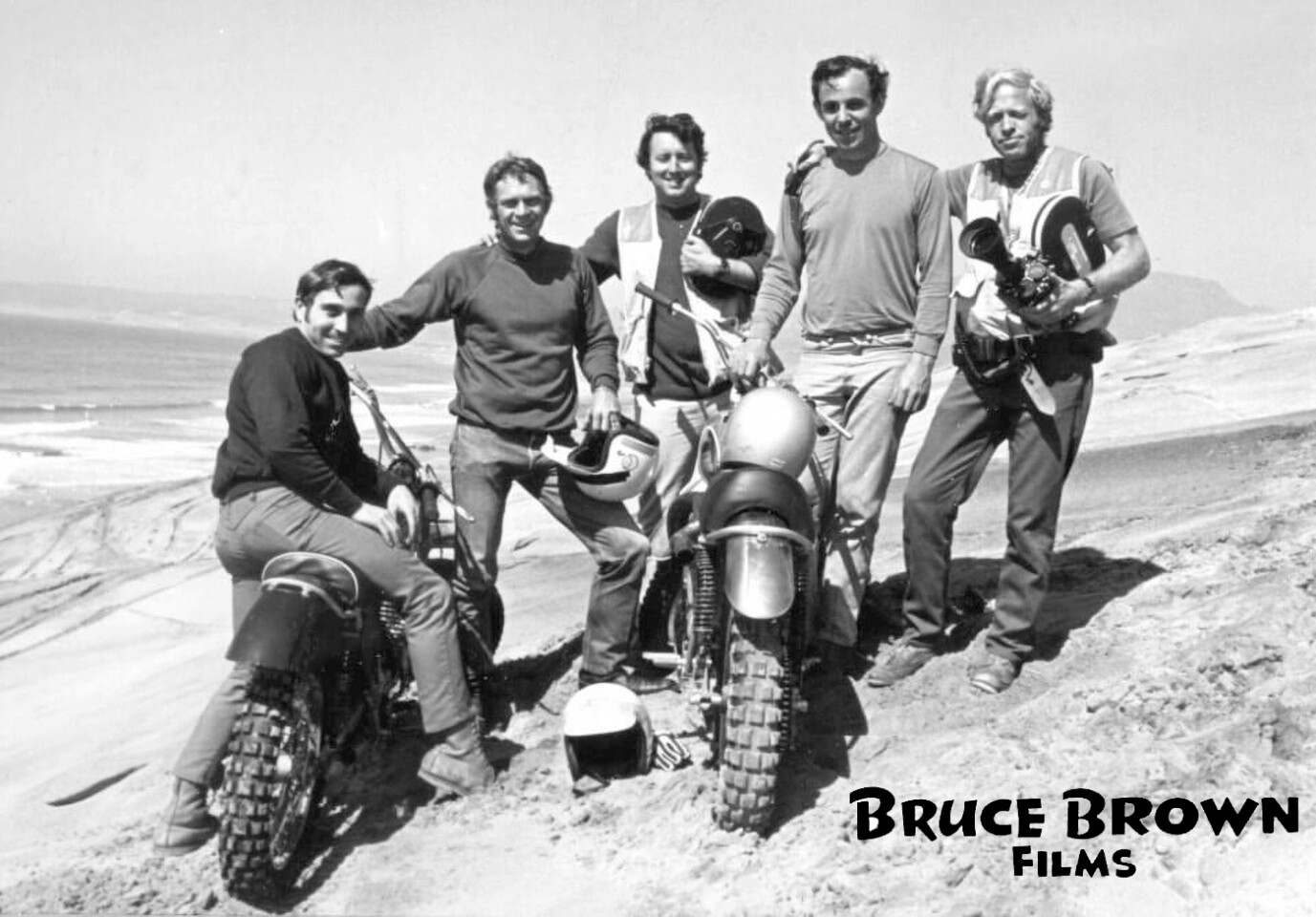 During the filming of On Any Sunday at Camp Pendleton. From left to right: 1969 AMA Grand National Championship Mert Lawwill , Steve McQueen, camera man (unknown), Malcolm Smith and Bruce Brown