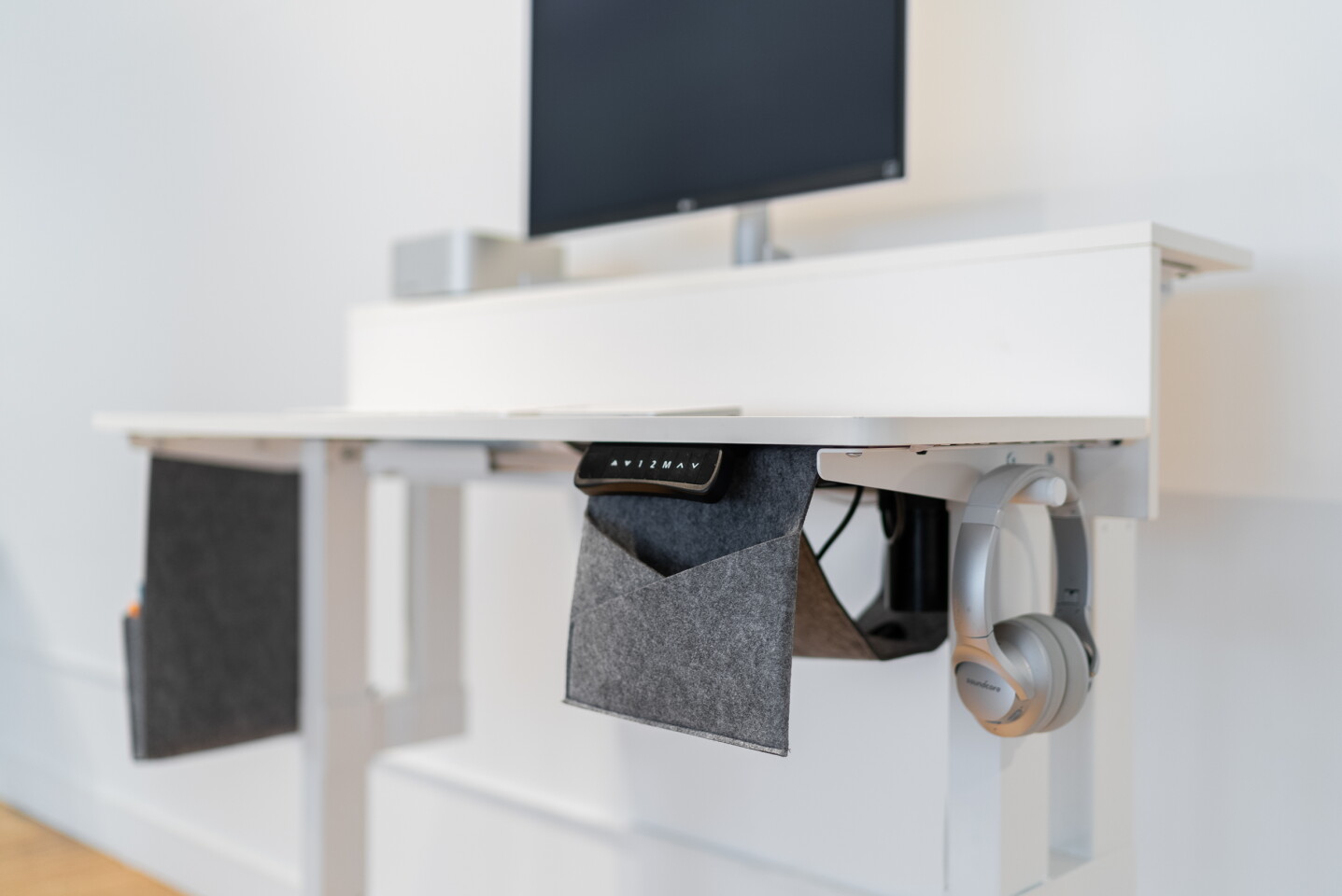 The Dual Lift Standing Desk comes with storage pouches to help keep the desktop clear of clutter, along with a handy headphone hanger