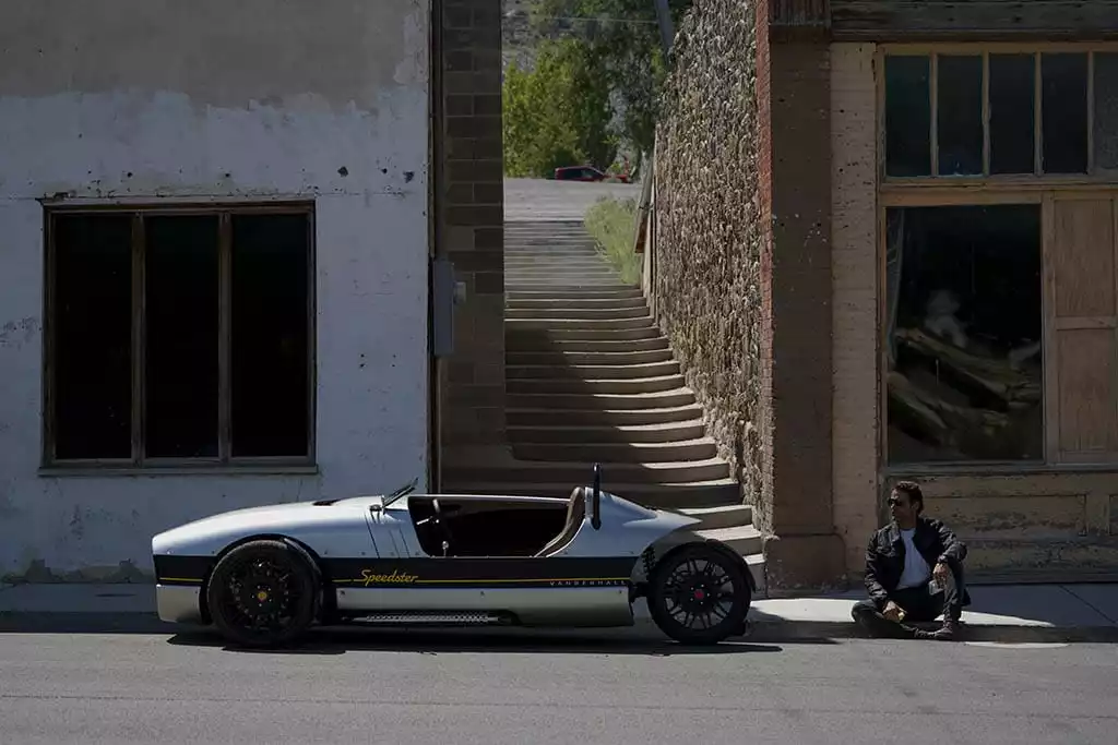 Man sits next to Vanderhall Speedster looking windswept and interesting, but he can't take you home no matter how impressed you are