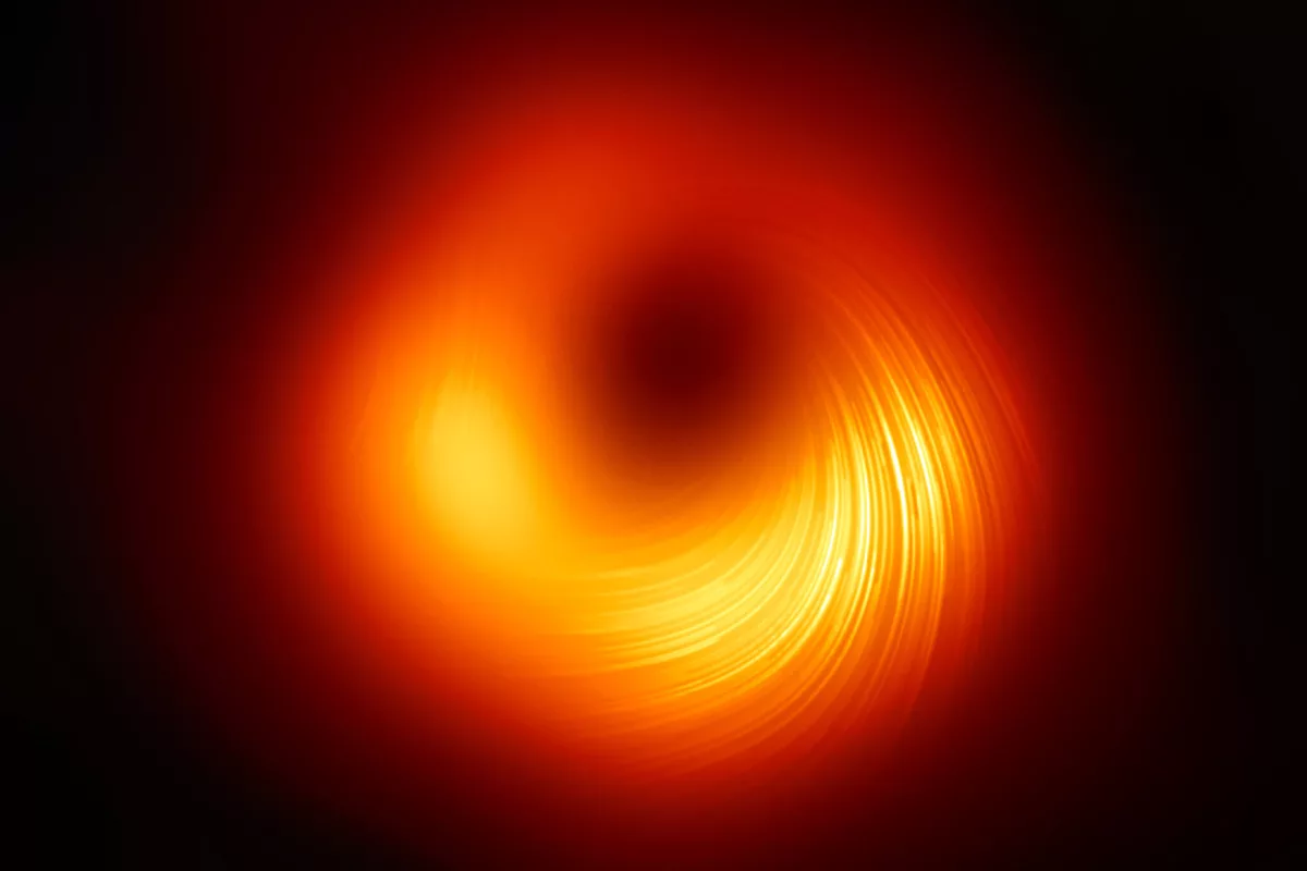 The Event Horizon Telescope (EHT) Collaboration's updated image of the black hole in the galaxy M87 – the white lines represent the polarization of light in the ring, which can reveal new clues about the magnetic field in this extreme environment