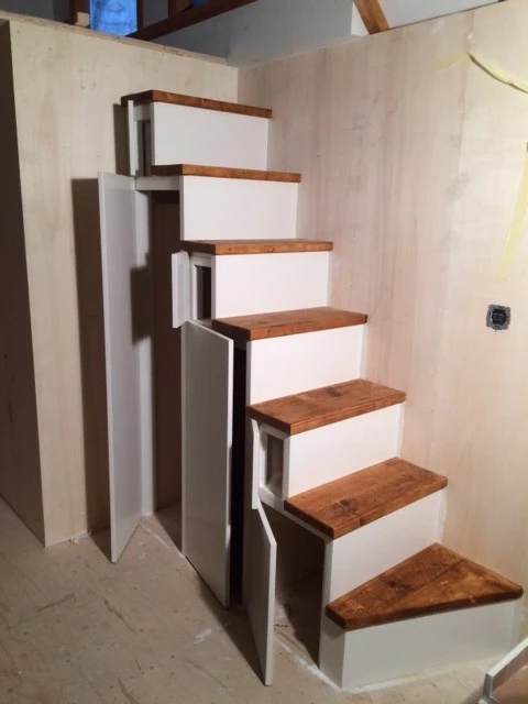 Stairs with integrated storage lead to the sleeping loft